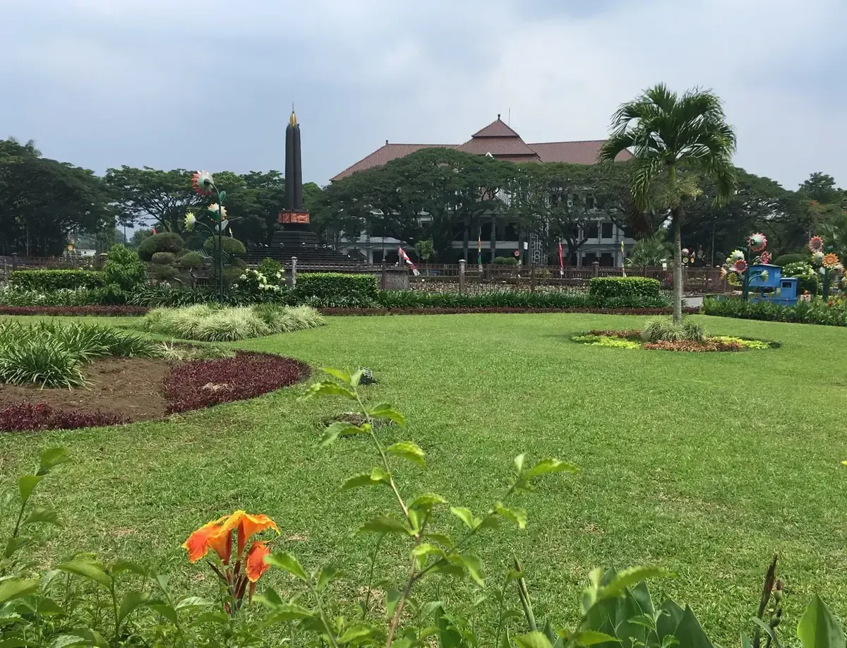 Alun-alun Tugu Malang dengan monumen tugu dan Balai Kota di latar belakang