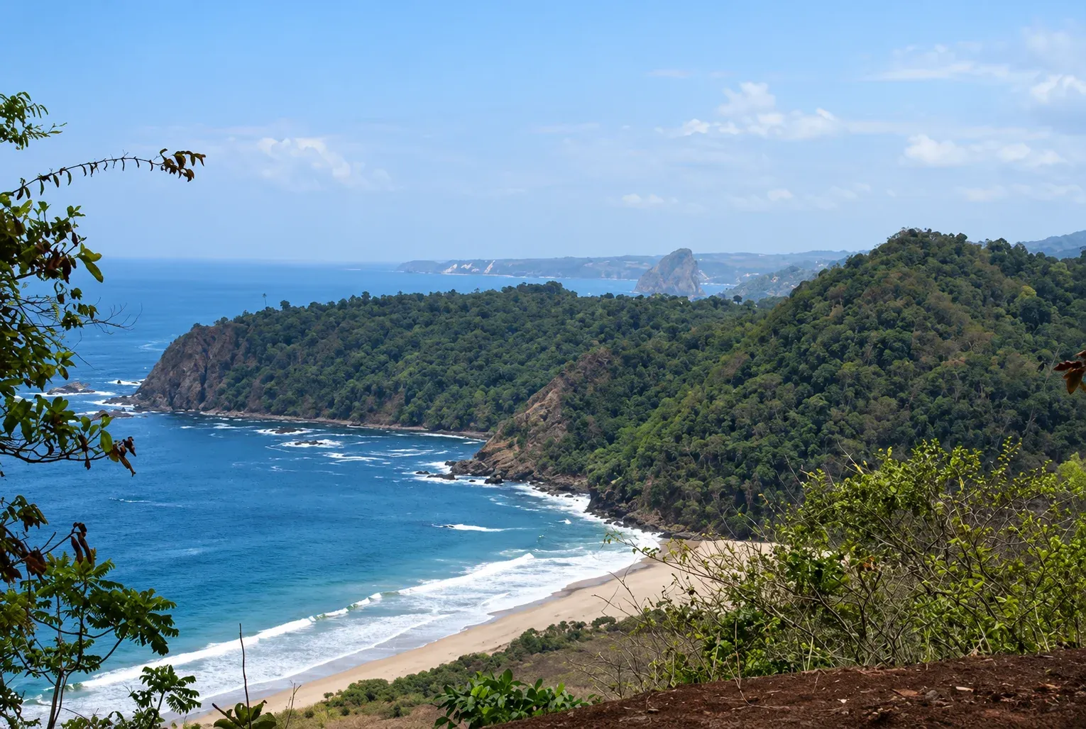 Panorama Pantai Modangan Malang dengan pasir putih, laut biru, dan bukit hijau