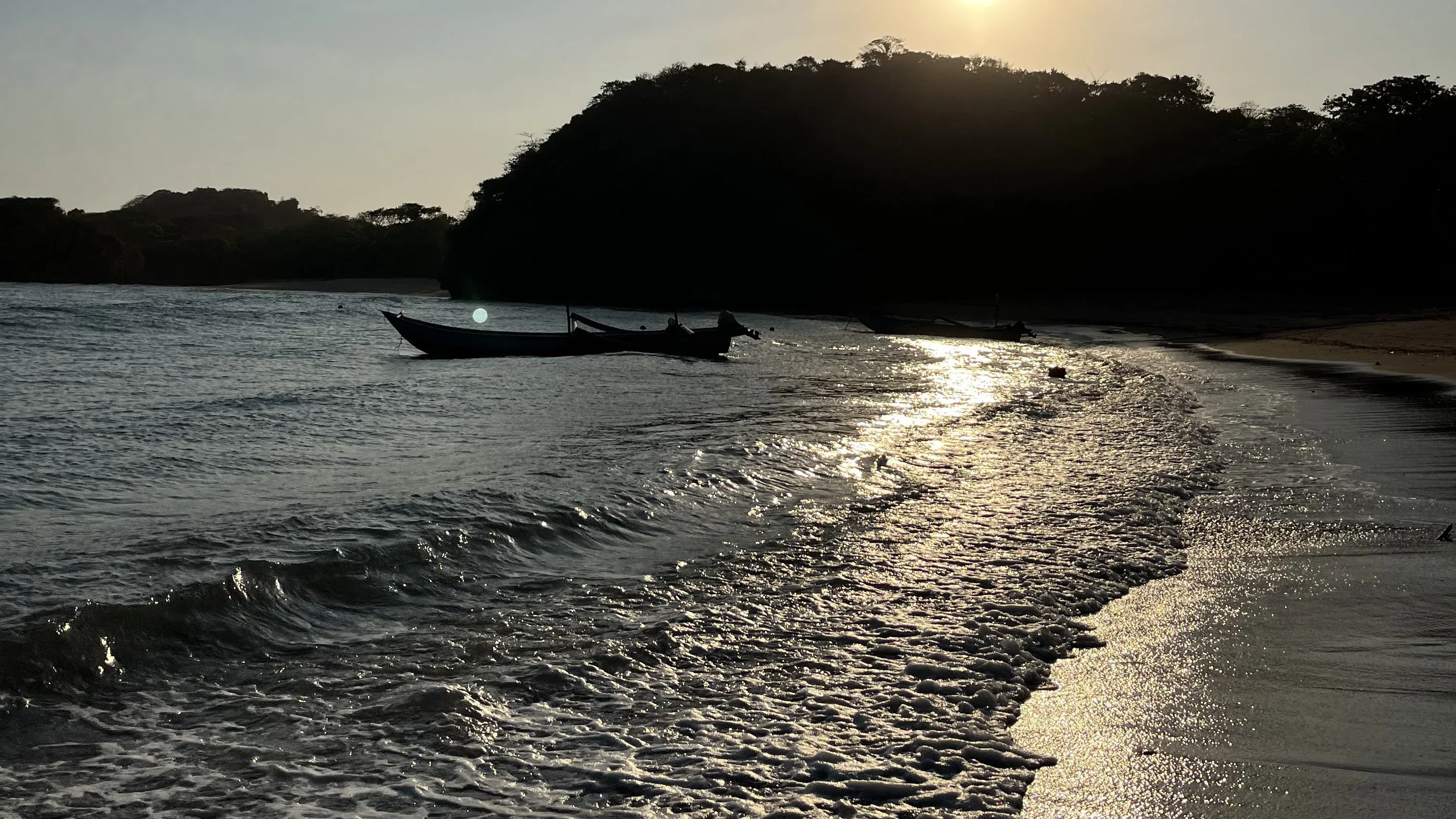 Matahari terbenam dengan perahu nelayan di Pantai Bantol