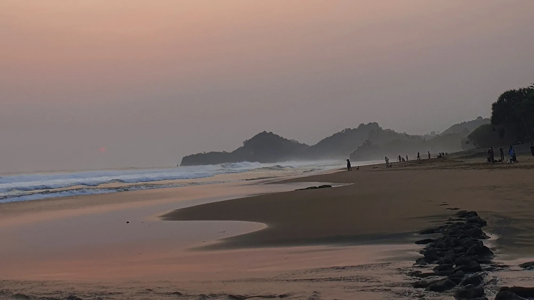 Senja di Pantai Wonogoro dengan pasir dan ombak